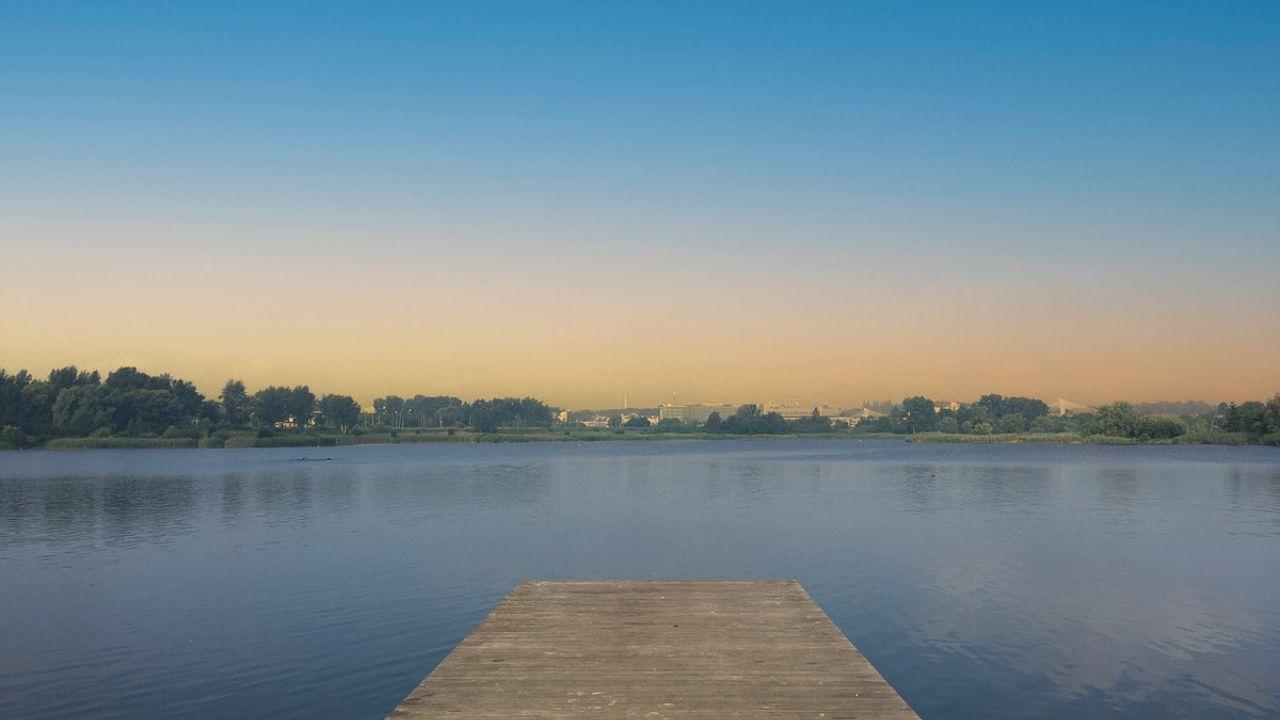 Bagry: "Blick auf den ruhigen Bagry-See bei Sonnenuntergang, menschenleer."
